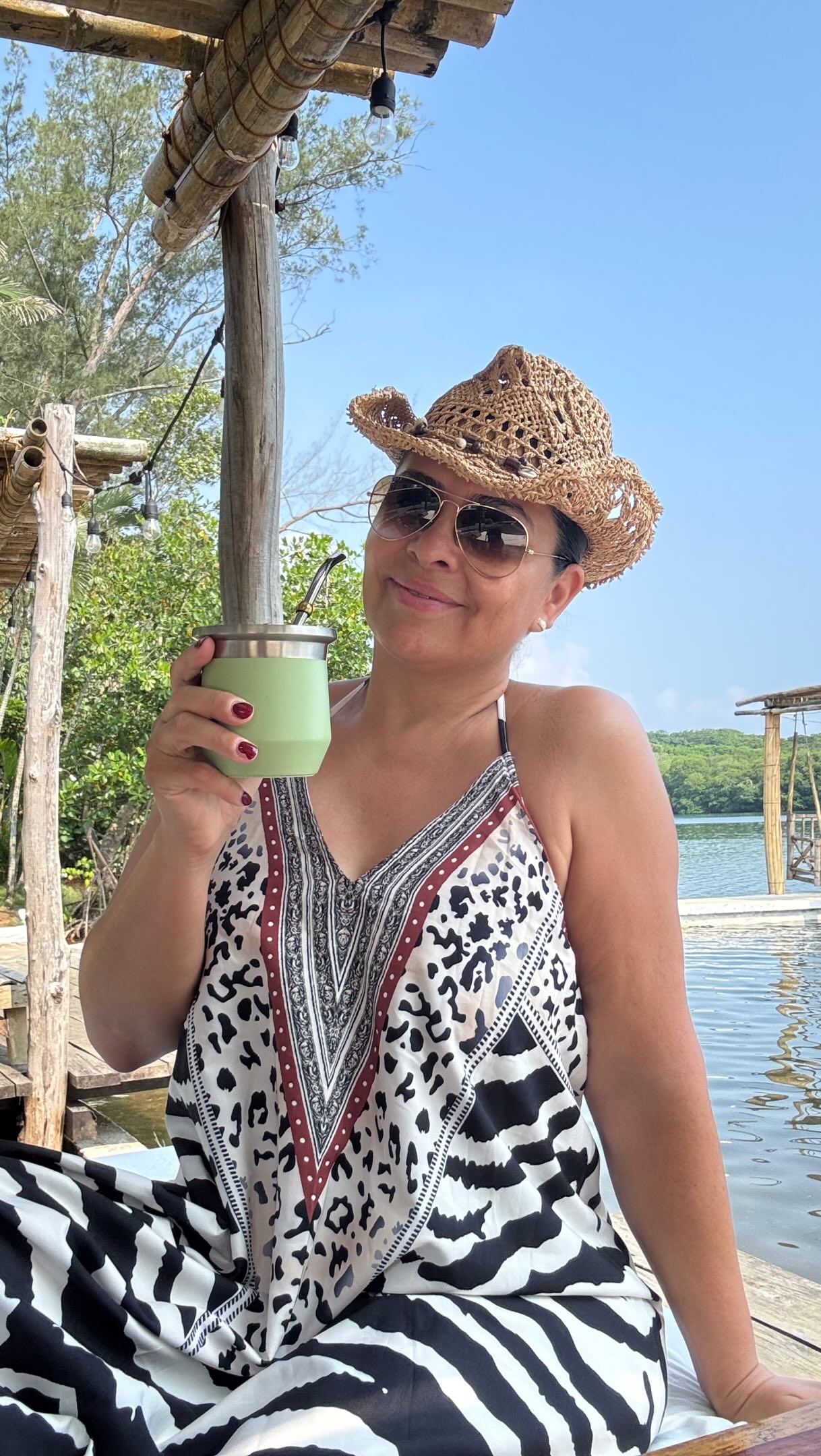Sol Pisthon junto al agua, disfrutando una bebida al aire libre